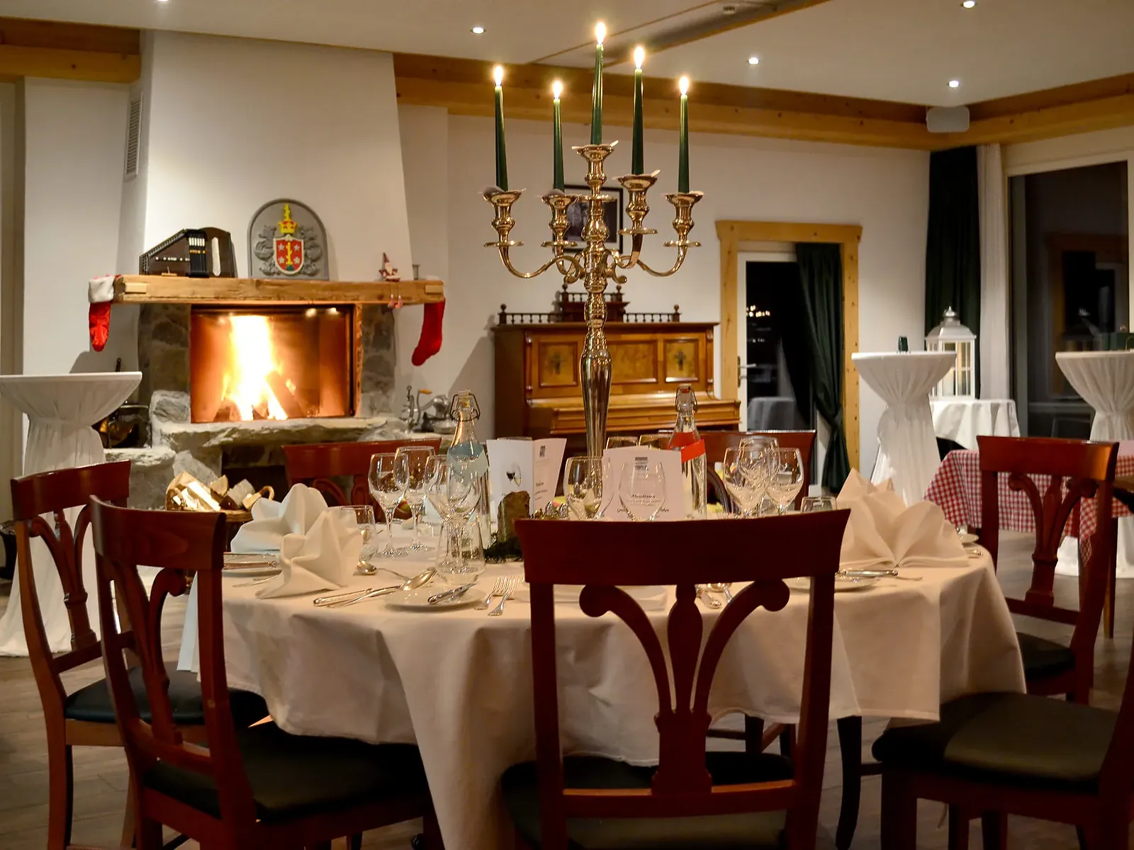 Festlich gedeckter Tisch im Hansen-Ritschard-Saal bei Kerzenlicht und Kaminfeuer