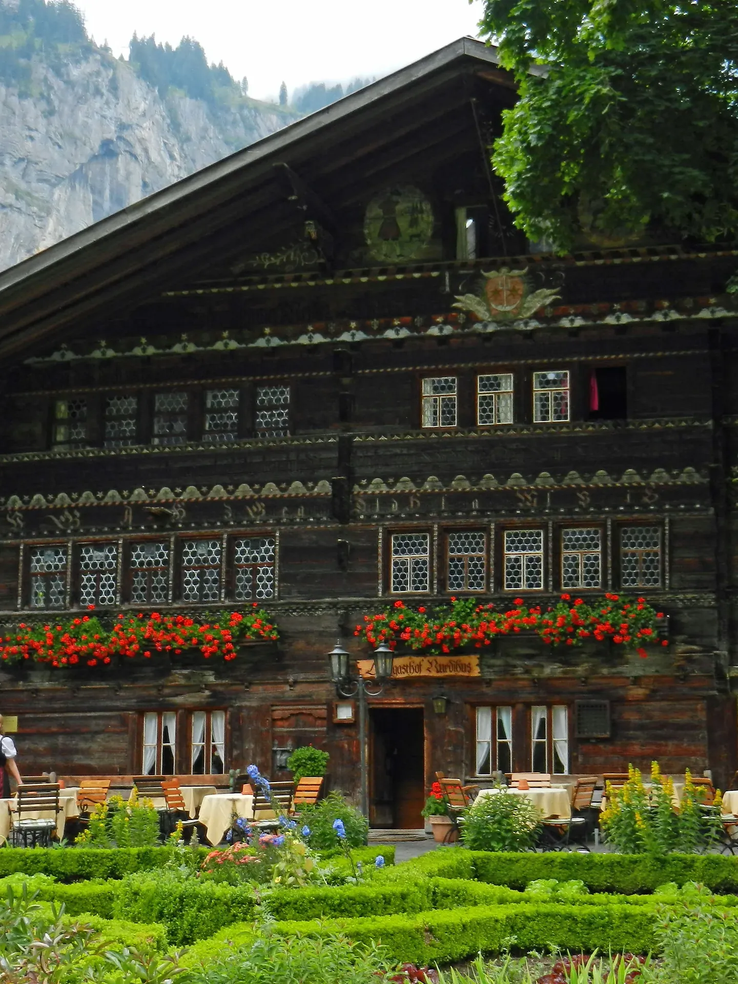 Die ganze Fassade des Ruedihus mit Fensterreihen, Geranien und Garten
